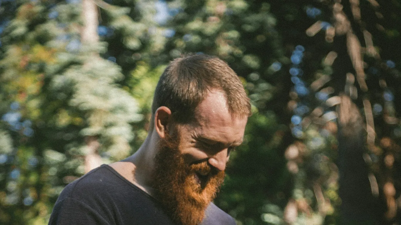a man with a red beard looking at his phone