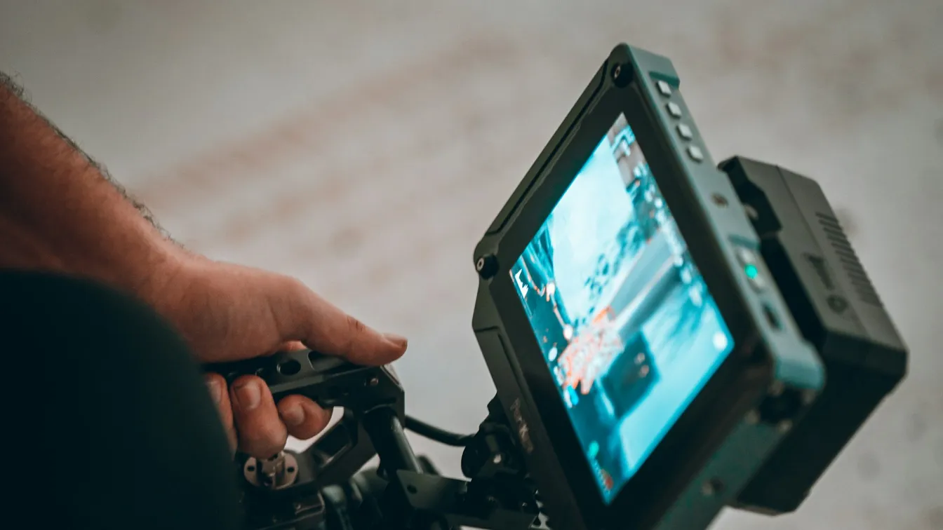 a person holding a video camera with a screen on it