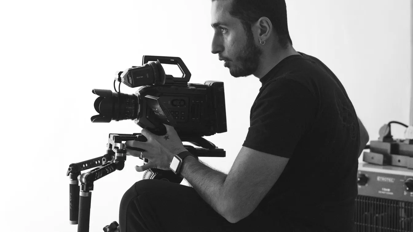 a man holding a camera while sitting on a chair
