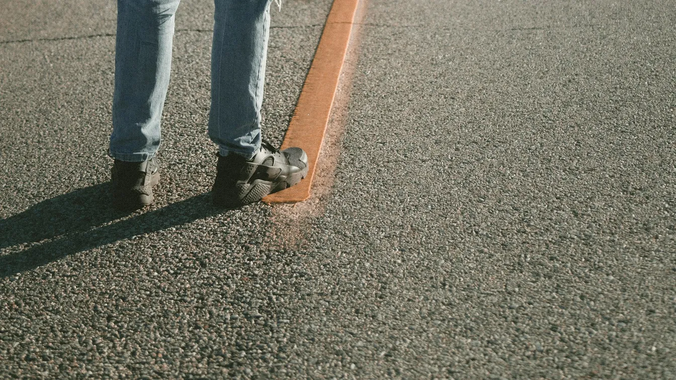 a person standing on a road with an orange line