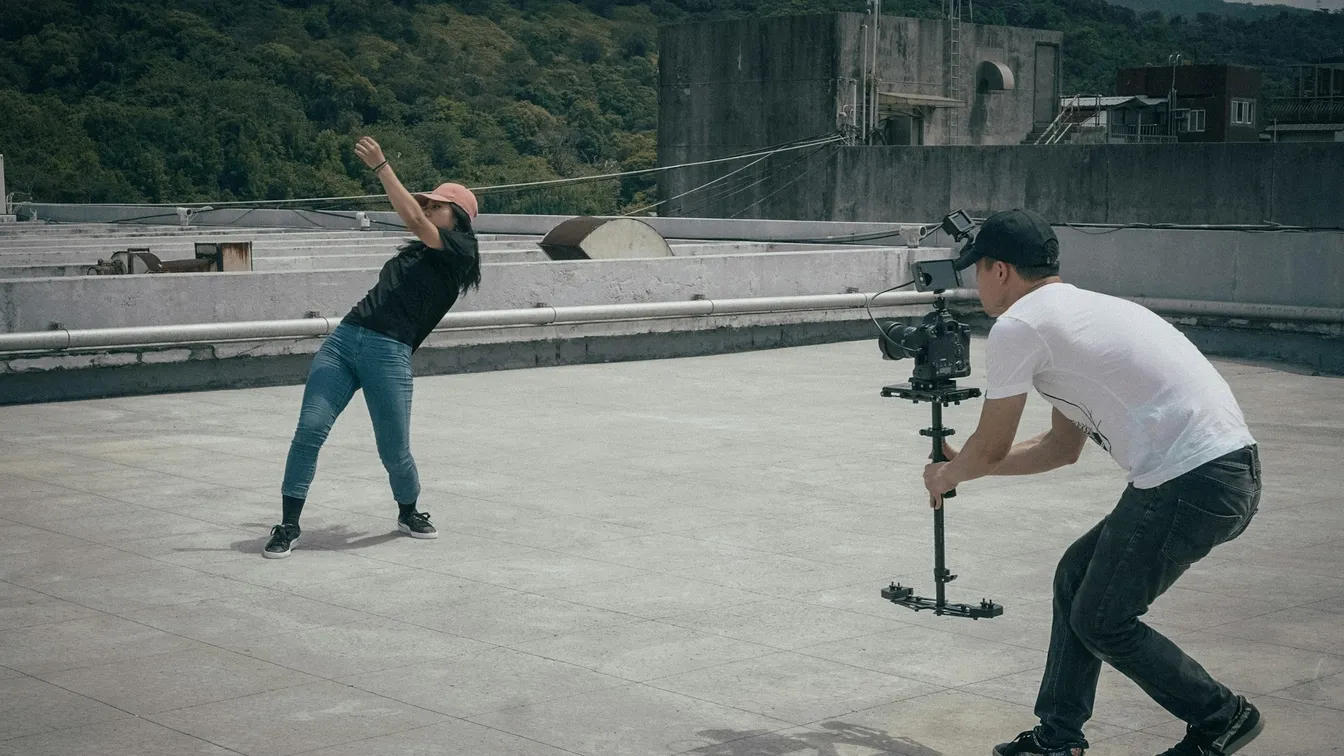 a man and a woman on a roof with a camera
